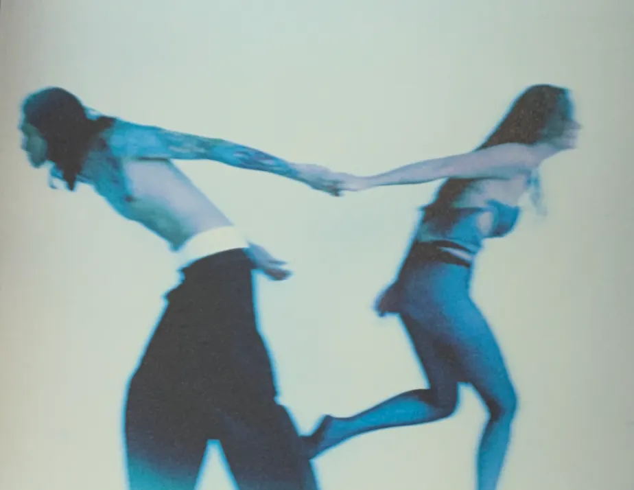 Two figures running while holding hands
