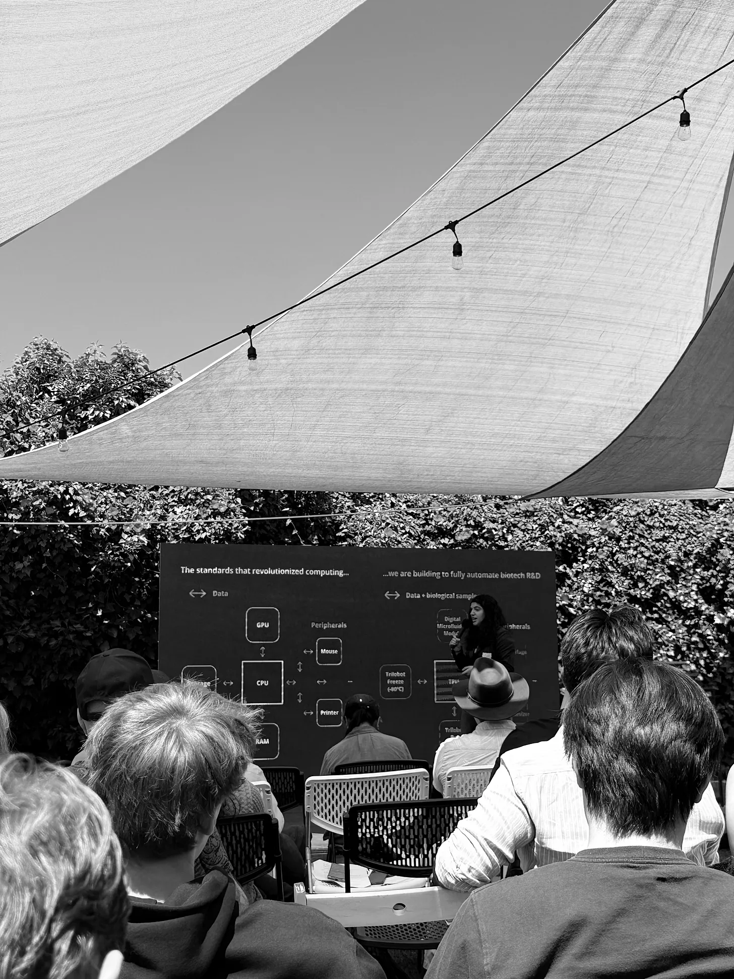 An outdoor technology talk beneath shade sails